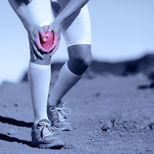 person holding knee from acl injury